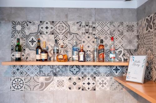 a bar with bottles of alcohol on a tile wall at Stil Hotel in Bucharest