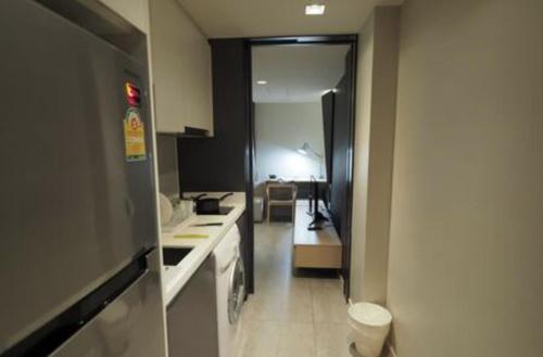 a kitchen with a hallway leading to a living room at Circle S Sukhumvit12 NearBTS,MRT in Bang Kapi