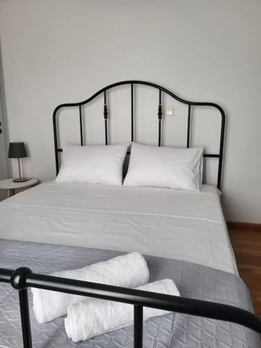 a bed with white sheets and pillows in a room at Kampi Apartment in Chora Folegandros