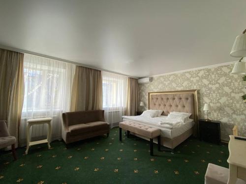 a hotel room with a bed and a chair at Skif HOTEL & SPA in Petropavlovsk
