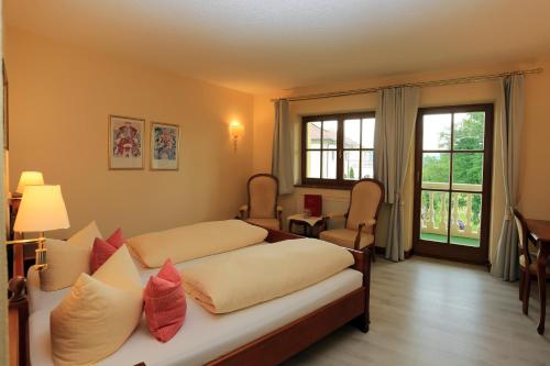 a bedroom with two beds and a window at Wellnesshotel Parkschlössl zu Thyrnau " Adults only" in Thyrnau