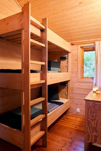 a room with bunk beds in a log cabin at Fjordhytte-1 ist eine schöne Hütte bei Ænes am Hardangerfjord mit grandiosem Fjordpanorama, 20 PS Motorboot mietbar in Ænes