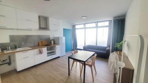une petite cuisine avec une table et un réfrigérateur dans l'établissement Studio indépendant de 30 m² - St Cléophas, à Montpellier