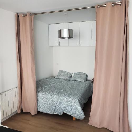 - une chambre avec un lit et un rideau dans l'établissement Studio indépendant de 30 m² - St Cléophas, à Montpellier