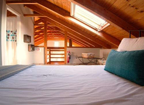 a bedroom with a white bed with a blue pillow at Villa Kounouvato in Perakhórion