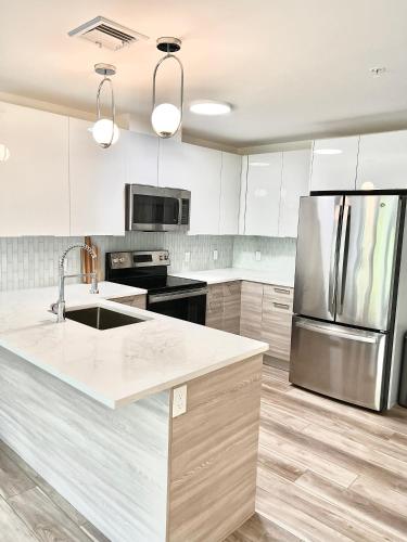 a kitchen with white cabinets and a stainless steel refrigerator at Luxury 2 Bed Apartment in Quincy in Quincy