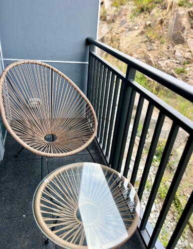 two wooden chairs and a glass table on a balcony at Luxury 2 Bed Apartment in Quincy in Quincy