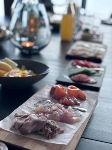 a wooden table with plates of food on it at Lyngen Experience Lodge in Nord-Lenangen