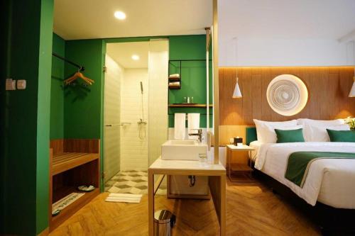 1 dormitorio con 1 cama y baño con ducha en Patra Malioboro Hotel, en Yogyakarta