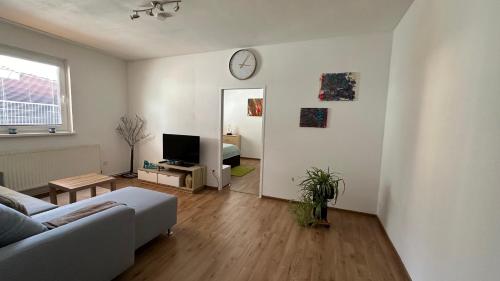 a living room with a couch and a clock on the wall at Ferienwohnung Casa Claudia in Liezen