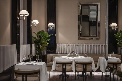 a restaurant with white tables and chairs and a mirror at Sanasaryan Han, a Luxury Collection Hotel, Istanbul in Istanbul