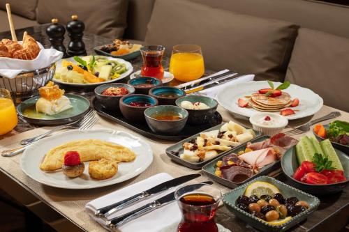 a table topped with plates of food and drinks at Sanasaryan Han, a Luxury Collection Hotel, Istanbul in Istanbul
