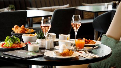 a table with plates of food and glasses of wine at Holiday Inn Dresden - Am Zwinger by IHG in Dresden
