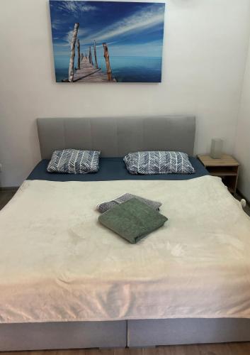 a bed with two pillows and a painting on the wall at DH Duomo III apartment in Košice