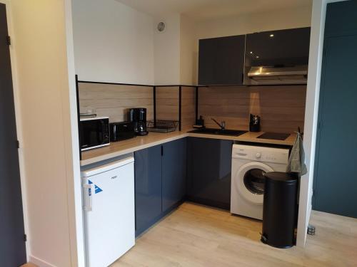 une cuisine avec un lave-linge et un lave-linge dans l'établissement OIQIA • Industriel, au Mans