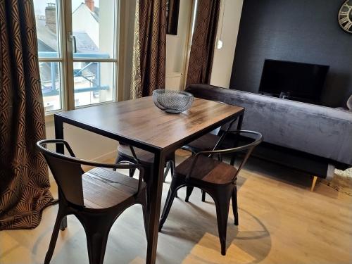 une table et des chaises en bois dans un salon dans l'établissement OIQIA • Industriel, au Mans