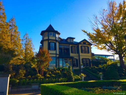 a large yellow house with a tower on top of it at ホテルアイエス in Yokohama