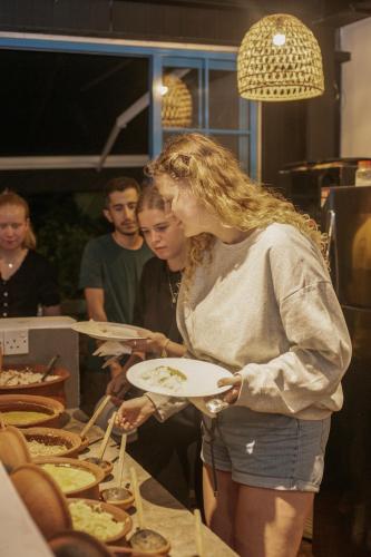 a woman is holding a plate of food at Hangover Hostels Ella in Ella
