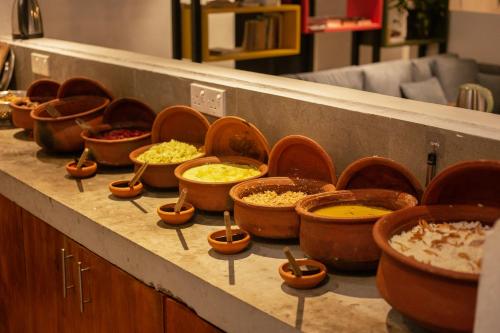a bunch of bowls of food on a counter at Hangover Hostels Ella in Ella