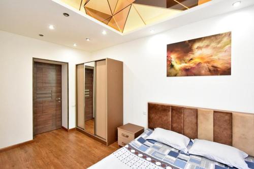 a bedroom with a bed and a painting on the wall at Luxe Apartment in the Center of Yerevan 007 in Yerevan