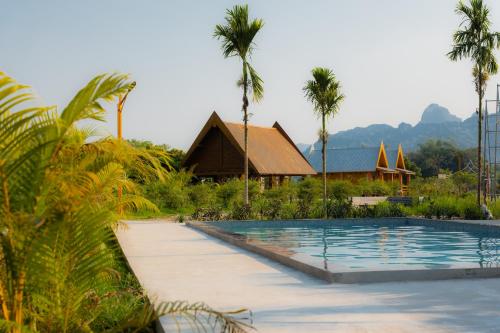 a resort with a swimming pool and palm trees at Vang Vieng Romantic Place Resort in Vang Vieng