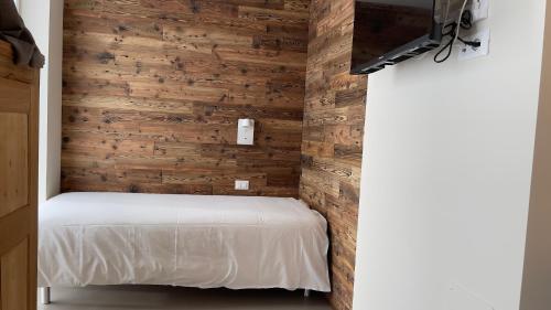 a small bedroom with wooden walls and a bed at Ca' De Sass in Pila