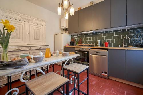 une cuisine avec une table et quelques chaises dans l'établissement La Casa Consuelo ~ Piscine ~ Jardin ~ Centre ville, à Carcassonne