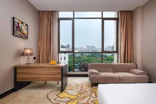 a living room with a couch and a large window at Caribbean Hotel Zhongshan in Zhongshan