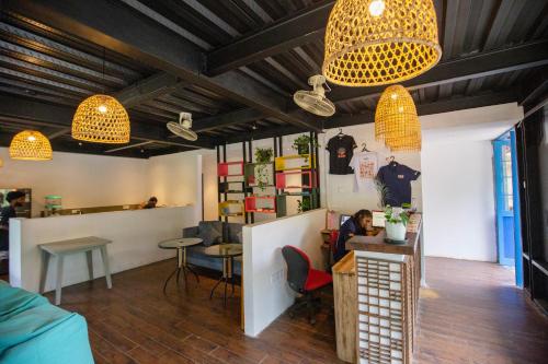 a person sitting at a table in a room with lights at Hangover Hostels Ella in Ella
