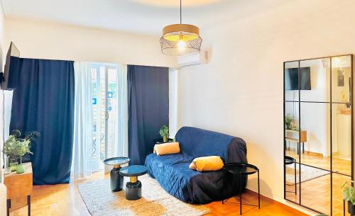 a living room with a blue couch and a mirror at Chez Ethan, 5 min à pied de l'Acropole in Athens