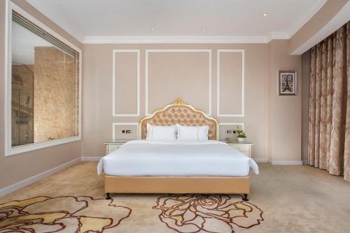 a bedroom with a large bed and a large window at Caribbean Hotel Zhongshan in Zhongshan