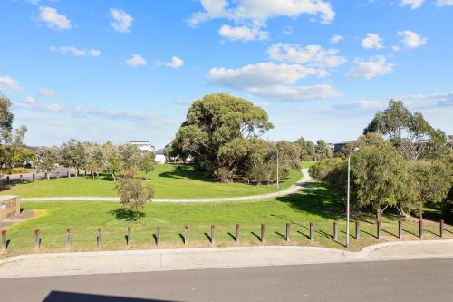 a grassy park with trees and a road at Grande Nisi Casa Cowes in Cowes