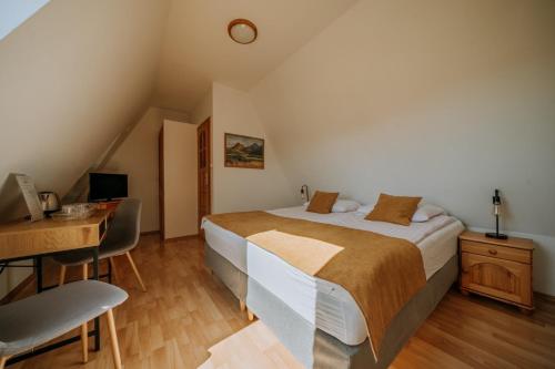a bedroom with a bed and a desk with a computer at Dom Wypoczynkowy U Staszla in Bańska