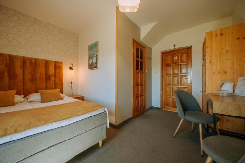 a hotel room with a bed and a desk and a chair at Dom Wypoczynkowy U Staszla in Bańska