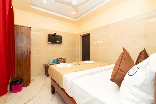 a bedroom with a bed and a tv on the wall at Amman Residency - Rameswaram in Rāmeswaram