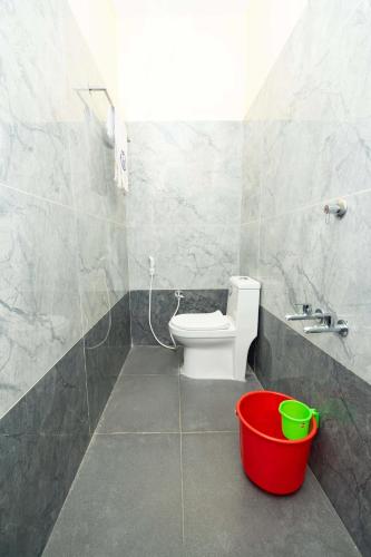 a bathroom with a toilet and a sink and a bucket at Amman Residency - Rameswaram in Rāmeswaram