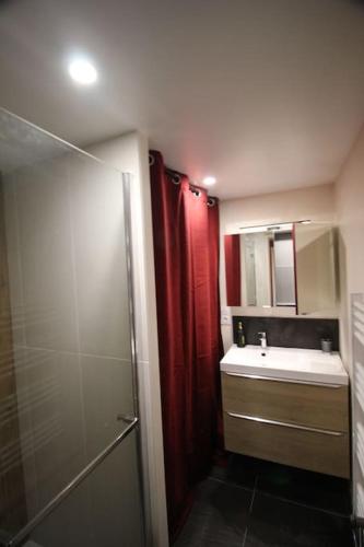 La salle de bains est pourvue d'une douche rouge et d'un lavabo. dans l'établissement A 800 m de la plage, app 6 pers avec billard, à Erquy