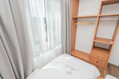 a bed in a room with a window and a shelf at Ipoh Tambun Lost World Sunway Onsen Mina 3R2B 8pax in Tambun