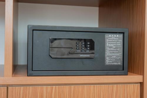 a microwave on top of a wooden shelf at Ipoh Tambun Lost World Sunway Onsen Mina 3R2B 8pax in Tambun