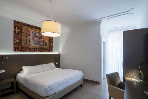 a bedroom with a bed and a painting on the wall at Hotel Delle Palme in Lecce