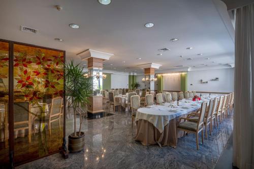 a dining room with tables and chairs in a room at Hotel Delle Palme in Lecce