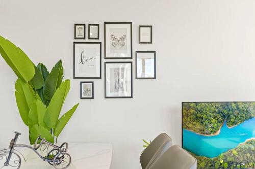 a living room with a wall of framed pictures at Cozy 2 Bedroom Apt at Waterloo in Sydney