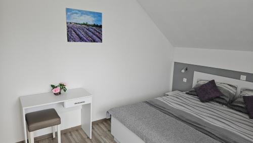 a small bedroom with a bed and a desk at Apartment Andrea in Smoljanac