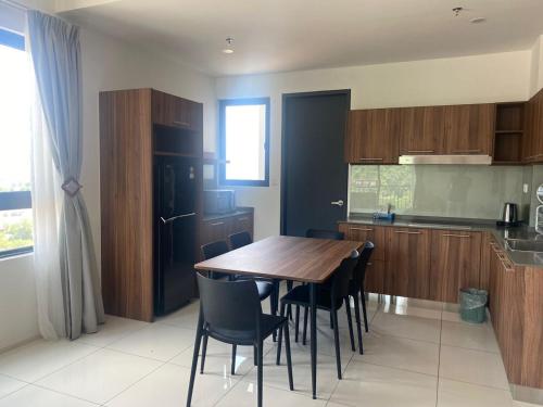 a kitchen with a wooden table and black refrigerator at Ipoh Tambun Lost World Sunway Onsen Mina 3R2B 8pax in Tambun