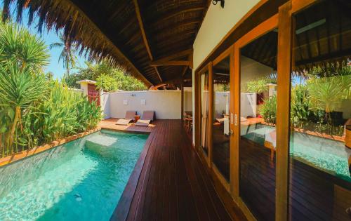 a house with a swimming pool next to a house at Pera ONE Villas in Gili Trawangan