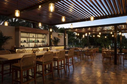 a restaurant with tables and chairs and a bar at W Dubai - Mina Seyahi in Dubai