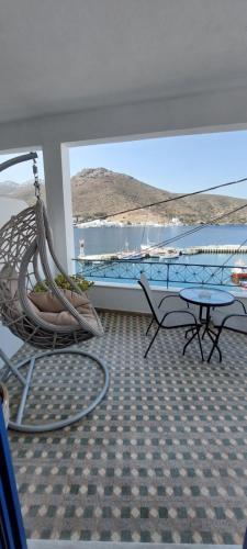 a room with a hammock and a view of a boat at Kalliopis Rooms in Katapola