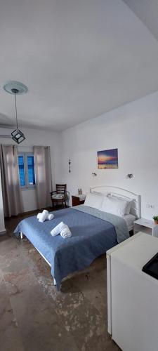 ein Schlafzimmer mit einem Bett mit zwei Handtüchern darauf in der Unterkunft Kalliopis Rooms in Katápola