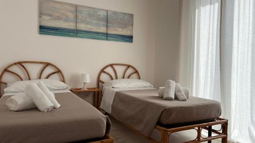 twee bedden naast elkaar in een slaapkamer bij IONIO Apartment in Porto Cesareo