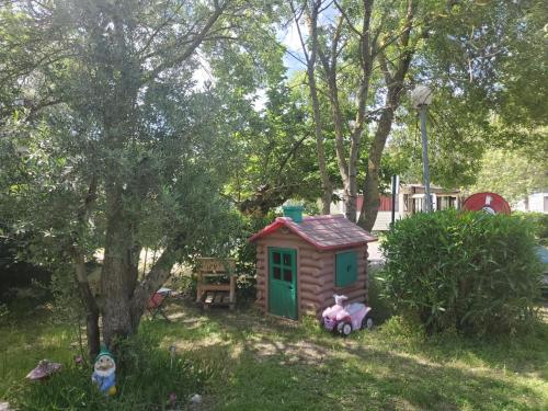 una pequeña casa de juguete en el patio con una mesa en Le Casita 3 ch, au calme, sur parcelle arborée, en Lattes